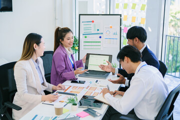 Business team woman and man asian group meeting sitting on desk looking talk think creative idea computer on table ready happy working new project job online product sale marketing in office company.