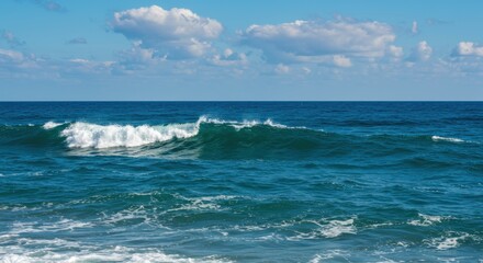 Fototapeta premium Serene Ocean Waves Under a Bright Blue Sky with Fluffy Clouds