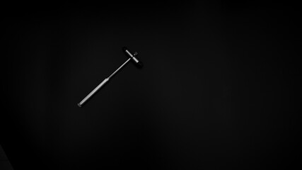 tuning fork C 128 on a black background with gradation and otorhinoscope and neurological hammer
