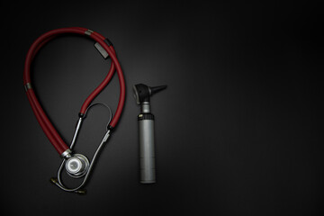 tuning fork C 128 on a black background with gradation and otorhinoscope and neurological hammer