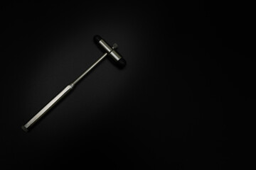 tuning fork C 128 on a black background with gradation and otorhinoscope and neurological hammer