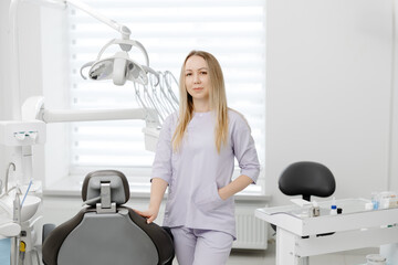 Dentist smiling in her dental office next to equipment