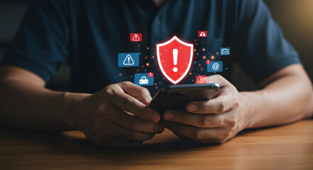 Person Holding Smartphone Showing Digital Shield Icon Over Wooden Table Displaying Security Related Symbols