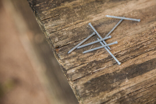 Scattered nails on wooden background