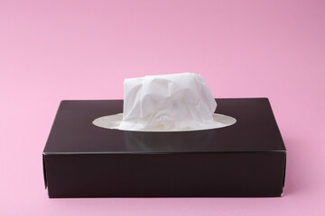 Box with paper handkerchiefs on pink background, closeup