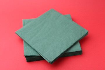 Stack of green handkerchiefs on red background, closeup