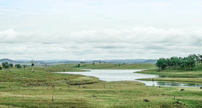 Green farmland with a lake and mountain view
