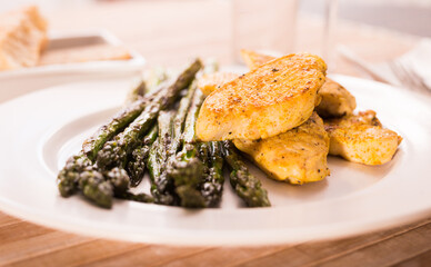 Cooked dish. Chicken nuggets with green asparagus on plate