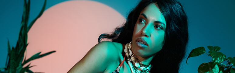 Beautiful young woman poses gracefully in vibrant summer fashion against a colorful backdrop