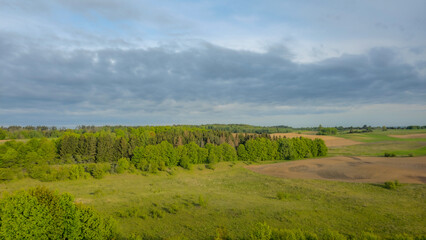 Expansive view of farmland and natural landscape in late afternoon light over rural countryside.