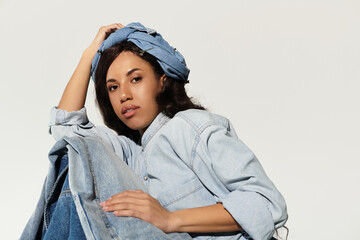 Capturing summer vibes with a stylish woman in denim lounging against a neutral backdrop