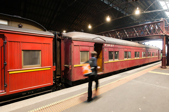 Conductor walking past a heritage carriage on a platform