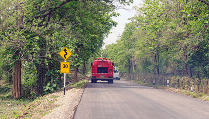 Obraz premium Traffic signs indicate winding roads and limit speeds on rural roads.