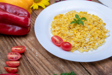 fresh scrambled eggs on white plate on breakfast table