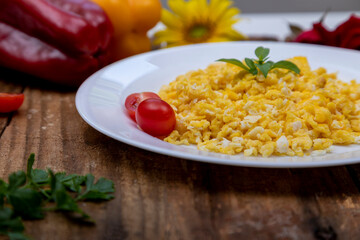 fresh scrambled eggs on white plate on breakfast table