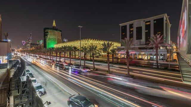 Aerial day to night timelapse of King Fahd Road in Riyadh, Saudi Arabia. Bustling traffic panorama with cars and taxis near the illuminated National Library surrounded by modern towers and skyscrapers