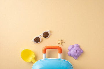Top view of summer travel items including suitcase, toys, sunglasses, and starfish, evoking holiday vibes