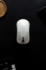 Wireless computer mouse on black background, top view for promotional branding.