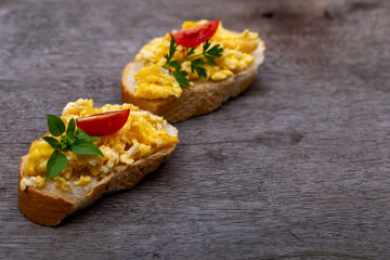 Scrambled eggs, delicious breakfast with herbs and tomatoes