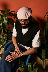 Charming man in stylish summer outfit surrounded by lush greenery exudes effortless cool