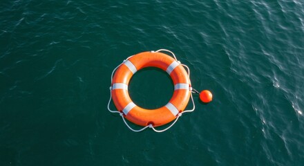 Orange lifebuoy with white stripes floating on calm water surface