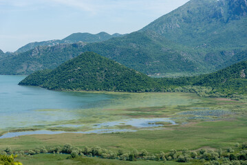 Landscape of blue deep lake, clouds in sky, mountains Skadar lake Montenegro