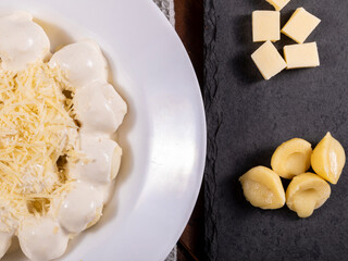 Potato gnocchi stuffed with cheese in white sauce