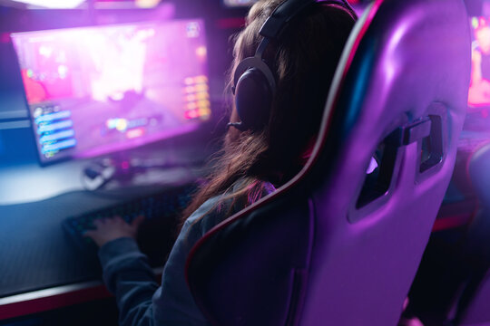 Young female caucasian gamer streaming in neon-lit room