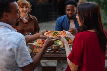 Fotobehang Group of people having pizza at a backyard dinner party © bernardbodo