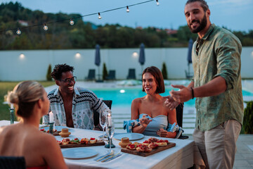 Friends enjoying a summer dinner party by the pool