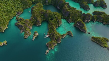 Raja Ampat, Indonesia: Aerial drone footage of the famous Piaynemo viewpoint plateform overlooking a stunning lagoon in the Fam islands in Raja Ampat in west Papua in Indonesia. - Powered by Adobe