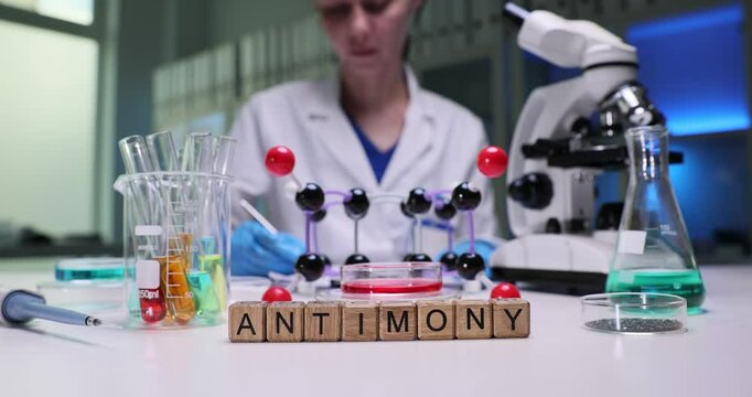 A researcher studies antimony in a lab, showcasing molecules and experiments for educational purposes.