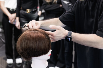 Hairstyling and barber education course in progress with students learning professional haircut...