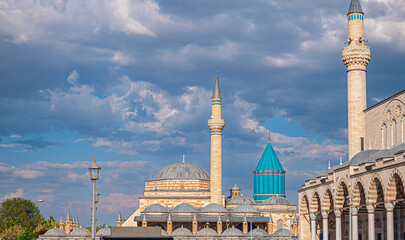 Mevlana tomb. Historic Mevlana Museum with minarets against a dramatic sky. Turkey, Konya. The blue-tiled dome adds a vibrant touch to the architectural beauty.