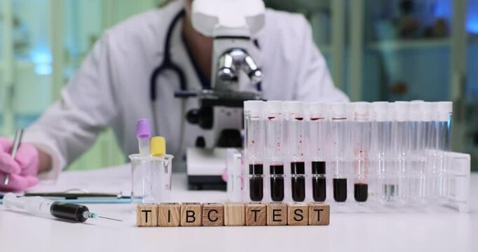 A closeup look at the preparation for a TIBC test, featuring test tubes, a microscope, and vital lab research tools