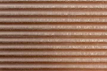 A close-up view of a textured, corrugated brown wall surface shows subtle patterns and lines that create a simple yet striking appearance. This design offers ample copy space for creative use.