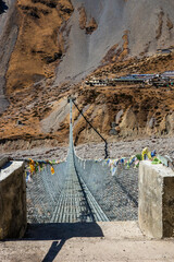 New long suspension bridge on the trekking route to Thorung Phedi. Annapurna circuit trek, Himalaya, Nepal.