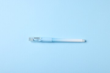 One stylish pen on light blue background, top view