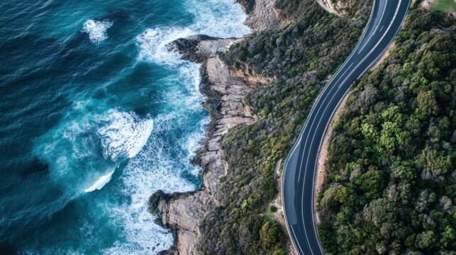 Aerial view of a winding coastal road alongside cliffs and the ocean, showcasing the scenic beauty of the landscape and transportation infrastructure.