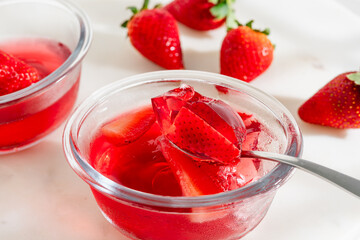 Strawberry slices suspended in glossy red jelly
