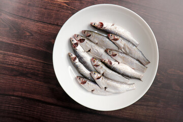 Indian White Mullet Fish or Boi Fish on green banana leaf with Spices and cooking ingredients on...