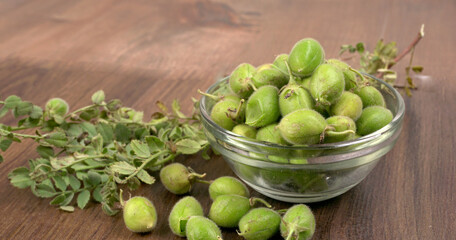 Fresh Green chickpeas on a branch, and in the pod, isolated on wooden background.