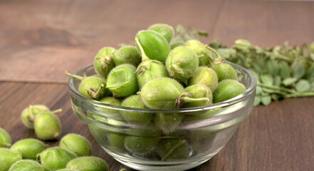 Fresh Green chickpeas on a branch, and in the pod, isolated on wooden background.