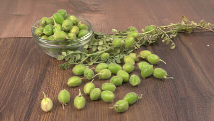 Fresh Green chickpeas on a branch, and in the pod, isolated on wooden background.