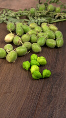 Fresh Green chickpeas on a branch, and in the pod, isolated on wooden background.