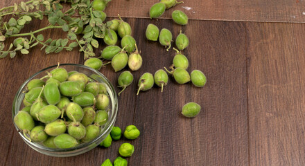 Fresh Green chickpeas on a branch, and in the pod, isolated on wooden background.