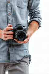 Fototapeta premium A man in a casual shirt firmly holds a digital camera, ready for taking a picture.