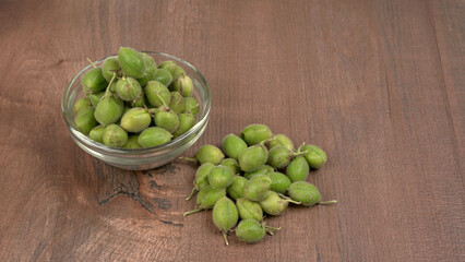 Fresh Green chickpeas on a branch, and in the pod, isolated on wooden background.
