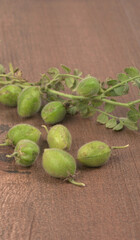 Fresh Green chickpeas on a branch, and in the pod, isolated on wooden background.