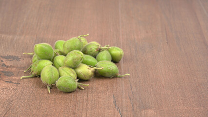 Fresh Green chickpeas on a branch, and in the pod, isolated on wooden background.